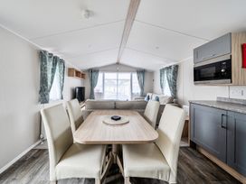 A living room with a dining area and sofa at Primrose Valley 3Bed Caravan Sleeps 8 Pets Ok Primrose Valley