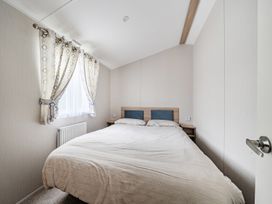 A bedroom with a bed and curtains at Primrose Valley 3Bed Caravan Sleeps 8 Pets Ok in Primrose Valley