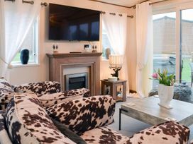 A living room with a sofa and television at Boutique lodge with hot tub sleeps 6 Bridlington