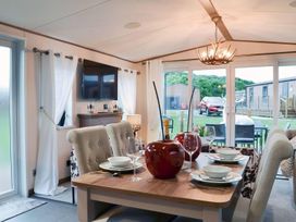 A dining room with a table and chairs at Boutique lodge with hot tub sleeps 6 Bridlington