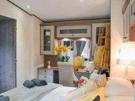 A bedroom with a bed, desk, and decor at Boutique lodge with hot tub sleeps 6 in Bridlington