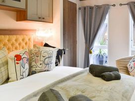 A bedroom with a bed and decorative pillows at Boutique lodge with hot tub sleeps 6 in Bridlington