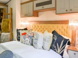 A bedroom with a bed and decorative cushions at Boutique lodge with hot tub sleeps 6 in Bridlington
