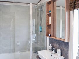A bathroom with a shower and sink at Boutique lodge with hot tub sleeps 6 in Bridlington