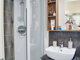 A bathroom with a shower and sink at Boutique lodge with hot tub sleeps 6 in Bridlington