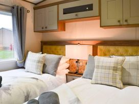 A bedroom with two beds and a lamp at Boutique lodge with hot tub sleeps 6 Bridlington