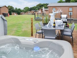 An outdoor area with a hot tub and dining table at Boutique lodge with hot tub sleeps 6 in Bridlington