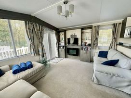 A living room with a sofa and television at 2Bed Ringwood Cabin incl Park Pass SelfCheckin Saint Leonards near Ferndown
