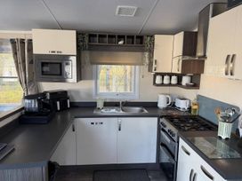 A kitchen with a microwave and cooking appliances at 2Bed Ringwood Cabin incl Park Pass SelfCheckin Saint Leonards near Ferndown