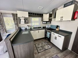 A kitchen with stove and microwave at 2Bed Ringwood Cabin incl Park Pass SelfCheckin, Saint Leonards near Ferndown
