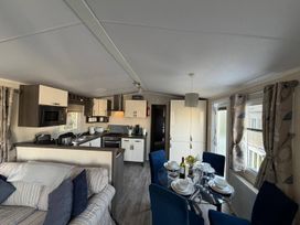 A living room and kitchen area with dining table and chairs at 2Bed Ringwood Cabin incl Park Pass SelfCheckin Saint Leonards near Ferndown