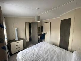 A bedroom with a bed and desk in 2Bed Ringwood Cabin incl Park Pass SelfCheckin Saint Leonards near Ferndown
