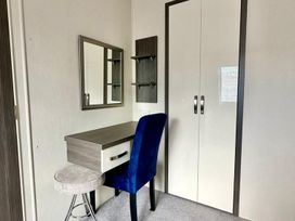 A bedroom with a desk and chair at 2Bed Ringwood Cabin incl Park Pass SelfCheckin Saint Leonards near Ferndown