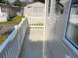 A deck with railing and entrance to a cabin at 2Bed Ringwood Cabin incl Park Pass SelfCheckin Saint Leonards near Ferndown