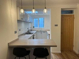 A kitchen with counter and bar stools at Charming 3Bed Cottage Private Garden Parking Torquay