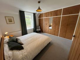 A bedroom with a bed and wardrobe at Charming 3Bed Cottage  Private Garden Parking in Torquay