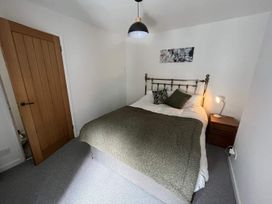 A bedroom with a bed and nightstand at Charming 3Bed Cottage Private Garden Parking in Torquay