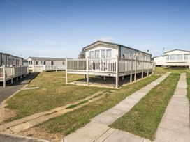 A static caravan with decking in an outdoor area at Cayton Bay Holiday Park Kestrel40 in Cayton Bay