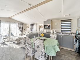 A kitchen with a table and chairs at Cayton Bay Holiday Park Kestrel40 in Cayton Bay