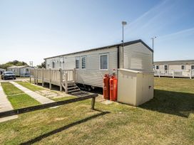 A caravan with decking and gas cylinders at Cayton Bay Holiday Park Kestrel40, Cayton Bay