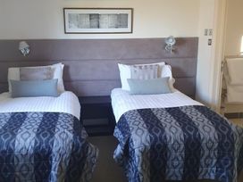 A bedroom with two single beds and wall art at 2bed sleeps4 pool freeparking Trenythonestate Near Par