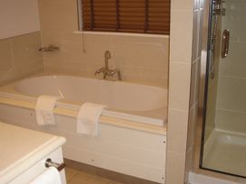 A bathroom with a bathtub and shower at 2bed sleeps4 pool freeparking Trenythonestate Near Par