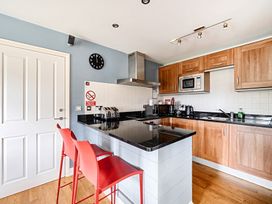 A kitchen with stools and appliances at 2bed sleeps4 pool freeparking Trenythonestate near Par