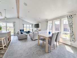 A living room with a sofa, armchair, and dining table at Atlantic Breeze Luxury Lodge sleep 6 Mullacott near Ilfracombe