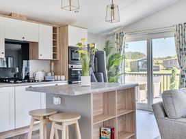 A kitchen with stools and appliances at Atlantic Breeze Luxury Lodge sleep 6 Mullacott near Ilfracombe