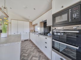 A kitchen with cabinets and appliances at Atlantic Breeze Luxury Lodge sleep 6 Mullacott near Ilfracombe