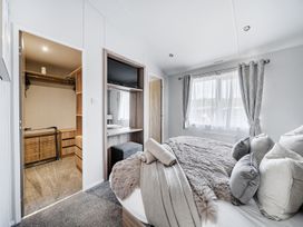 A bedroom with a bed and a closet at Atlantic Breeze Luxury Lodge sleep 6 Mullacott near Ilfracombe
