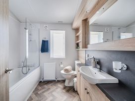 A bathroom with bathtub, shower, and sink at Atlantic Breeze Luxury Lodge sleep 6 Mullacott near Ilfracombe