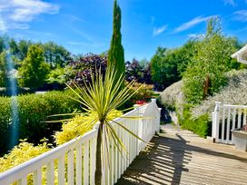 An outdoor area with a wooden deck and plants at Stunning Sleeps 6 Luxury Lodge Pets Mercia Marina near Willington, Derbyshire