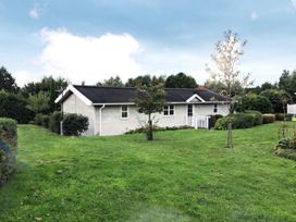 A house with a lawn and trees at Stunning Sleeps 6 Luxury Lodge Pets Mercia Marina near Willington, Derbyshire