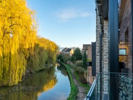 A view of a canal with trees and houses at The Old Barn in Manchester