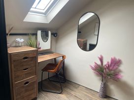 An office with a desk, mirror, chair, and plants
