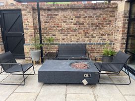 An outdoor seating area with a fire pit and planters at 