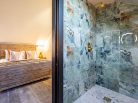 A bedroom with a wooden bed and an adjacent shower area