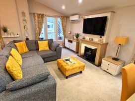 A living room with a sofa and television at Meadows 33 Hot tub Southview Holiday Park Skegness