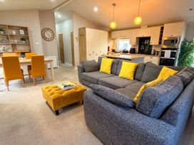A living room with a sofa and dining table at Meadows 33 Hot tub Southview Holiday Park Skegness
