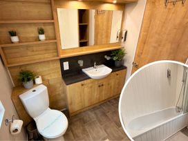 A bathroom with a sink, toilet, and bathtub at Meadows 33 Hot tub Southview Holiday Park Skegness