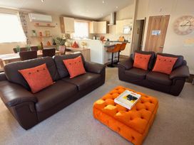 A living room with sofas and a dining area at Sunset 19 Southview Holiday Park Skegness