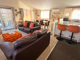 A living room with seating and a dining area at Sunset 19 Southview Holiday Park Skegness