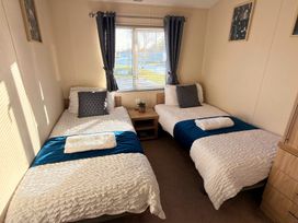 A bedroom with two beds and a nightstand at Sunset 19 Southview Holiday Park Skegness