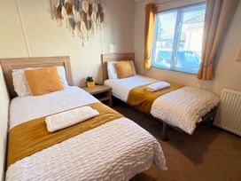 A bedroom with two single beds and a window at Sunset 19 Southview Holiday Park Skegness