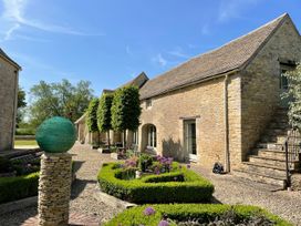 An exterior view of a house with garden features at Stunning 6 Bedroom Riverside Barn Cotswold Mill Ewan near Kemble