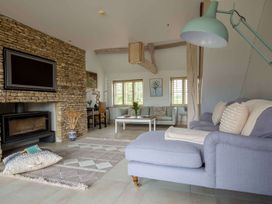 A living room with a sofa and coffee table at Stunning 6 Bedroom Riverside Barn Cotswold Mill Ewan near Kemble