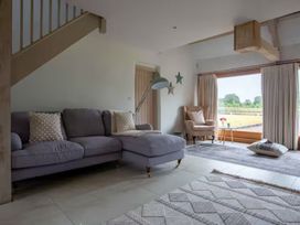 A living room with a sofa and armchair at Stunning 6 Bedroom Riverside Barn Cotswold Mill, Ewan near Kemble