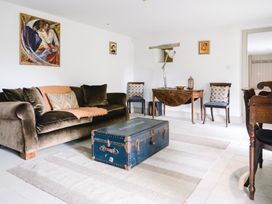 A living room with a sofa and trunk at Stunning 6 Bedroom Riverside Barn Cotswold Mill Ewan near Kemble