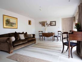 A living room featuring a sofa and dining table at Stunning 6 Bedroom Riverside Barn Cotswold Mill Ewan near Kemble